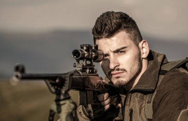Av mevsiminde avlanma süreci. Erkek avcı avlanmaya hazır. - Yakın çekim. Avcı adam. Av zamanı. Silahlı bir erkek, tüfek. Adam av tüfeğine saldırıyor.