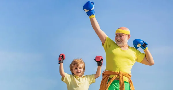 Little boy sportsman at boxing training with coach. Sports man coaching boxing little boy in red boxing gloves. Little boy doing boxing exercise with grandfather — Stock Photo, Image
