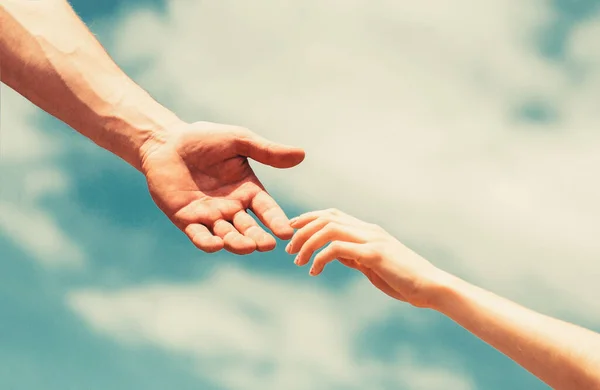 Рука допомоги. Руки чоловіка і жінки, що досягають один одного, підтримка. Руки чоловіка і жінки на фоні блакитного неба. — стокове фото