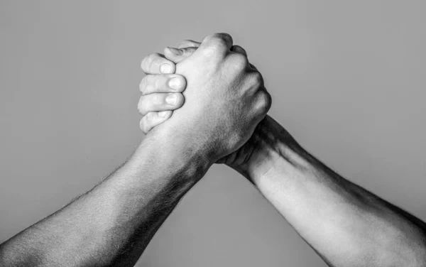 Friendly handshake, friends greeting, teamwork, friendship. Handshake, arms, friendship. Hand rivalry vs challenge strength comparison.