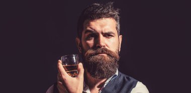 Sakallı adam cam brendi tutuyor. Sakallı konyak.