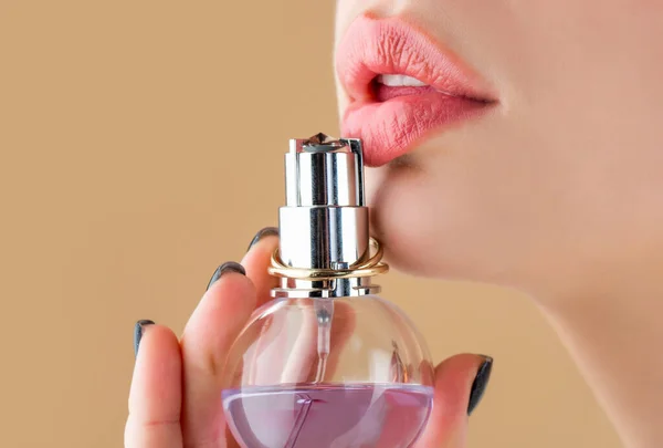 Vrouw parfumeert fles. Sexy lippen. Roze lip. Sluiten van sexy mollige zachte lippen met donkerrode lippenstift. Mooi meisje met parfum. Vrouw met een fles parfum. Vrouw presenteert parfums geur — Stockfoto