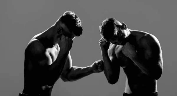 Deux jeunes boxeurs face à face dans un match. Deux boxeurs hommes boxant sur fond de silhouette isolé. Deux hommes pratiquant la boxe thaï, MMA. Deux boxeurs professionnels. Noir et blanc — Photo