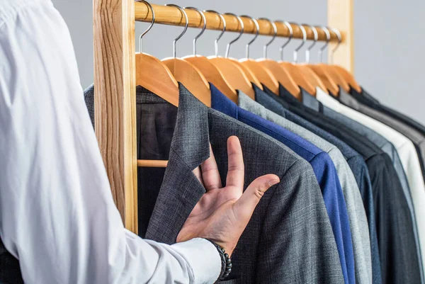 Trajes masculinos colgando en fila. Ropa de hombre, boutiques. Traje de hombre, a medida en su taller. Hombre de moda en traje clásico. Sastre, sastrería. Elegante traje para hombre — Foto de Stock