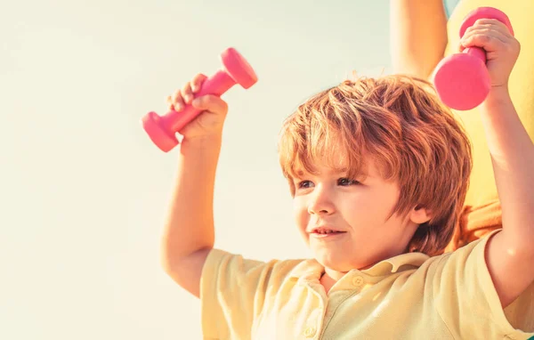 Fitness, health and energy. Healthy lifestyle. Cheerful boy do exercises with dumbbells. Fitness child. Kid exercising with dumbbells. Sport for little children — Stock Photo, Image