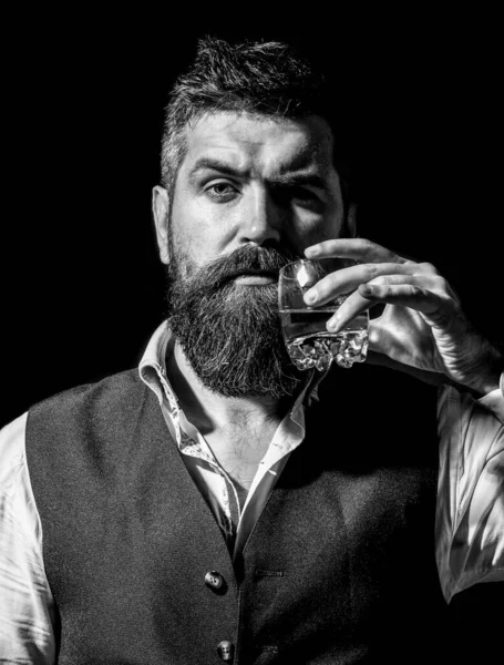 Omul de afaceri cu barbă în costum elegant, cu pahar de whisky. Degustare, degustare. Omul cu barbă ţine pahar de coniac. Negru și alb — Fotografie, imagine de stoc