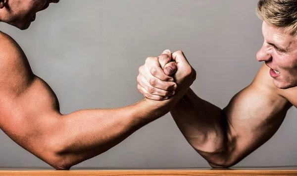 레슬링이요. 두 사람 이 팔 씨름을 한다. 경쟁적 이고, 남성의 팔 씨름을 막아내고 있습니다. 두 손으로. 남자들은 힘 과팔을 측정 합니다. 손 씨름, 경쟁. 사람의 손이나 팔. 근육통 — 스톡 사진