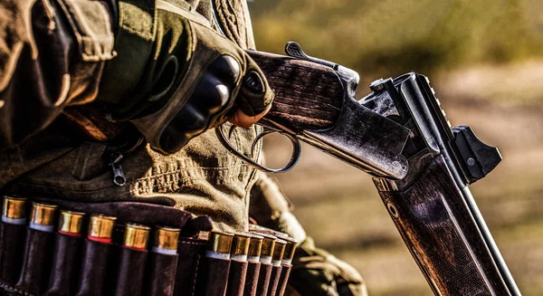 Un chasseur. Période de chasse, saison d'automne. Un homme armé. Un chasseur avec un fusil de chasse et une forme de chasse pour chasser dans une forêt d'automne. L'homme est à la chasse. Chasseur avec un sac à dos et un pistolet de chasse — Photo