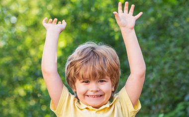 Mutlu çocuklar elleri havada çocuk. Doğada bir çocuk. Mutlu çocuk. Yeşil ağaçların arka planında izole edilmiş komik erkek bebek. Gülümseyen çocuk. Neşeli neşeli çocuk. Tatlı bir çocuğun portresi.
