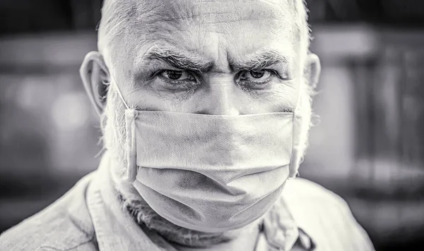 Coronavirus, illness, infection, quarantine, medical mask. Old man wearing face mask. Closeup