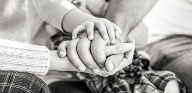 Birlik, destek, koruma, mutluluk kavramı. Çocuk eli ebeveynlere yakın çekim. Baba, anne, elinizi tutun küçük bebek. Siyah ve beyaz