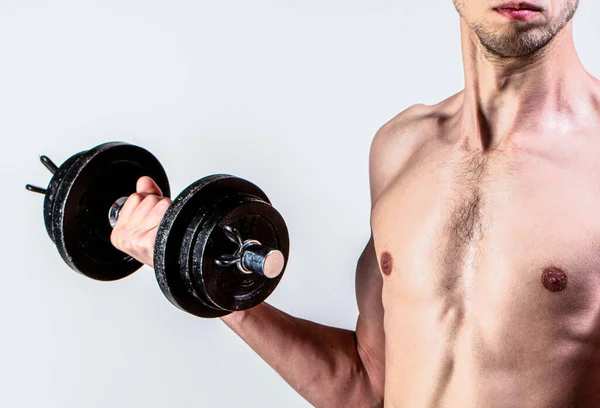 Hombre débil levantar un peso, pesas, bíceps, músculos, fitness. Nerd maltratando una mancuerna. Hombre sosteniendo la mancuerna en la mano. El flaco sostiene pesas en las manos. Un hombre delgado en deportes con mancuernas — Foto de Stock