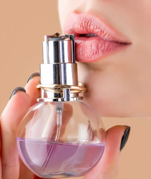 Женщина представляет аромат духов. Женщина духи бутылку. Сексуальные губы. Розовая губа. Закрыть сексуальные пухлые мягкие губы с темно-красной помадой — стоковое фото