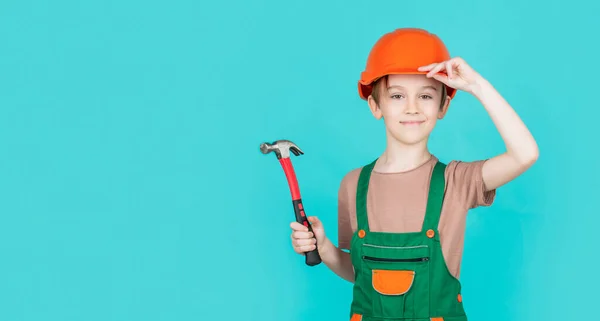 Kind verkleed als arbeider bouwer. Kleine jongen met een helm op. Portret kleine bouwer in harde hoeden hamer. Kinderhelm, harde hoed. Hamer hameren — Stockfoto