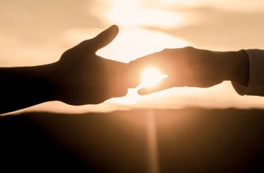 Yardım eli, siluet, konsept yardımı. Yardım eli uzatıyorum. Kurtarma, el hareketlerine yardım etme. Gökyüzü arka planında iki el silueti, bağlantı veya yardım kavramı
