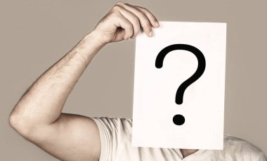 İnsan portresi, sorgulama sembolünün arkasına bakıyor. Erkek izole edilmiş. Bir sorum var. Soru işareti tutan şüpheli bir adam. Sorunlar ve çözümler. Soru işareti, sembol. Düşünceli erkek