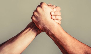Erkek eli. İki adam bilek güreşi yapıyor. Bilek güreşi. Kapatıyoruz. Dostça tokalaşma, dostça selamlaşma, takım çalışması, arkadaşlık. El sıkışma, silah, arkadaşlık. El, rekabet, meydan okuma, güç karşılaştırması