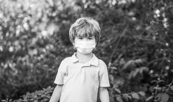 Criança usando máscara facial durante o vírus da corona e surto de gripe. Rapaz com uma ligadura cirúrgica — Fotografia de Stock