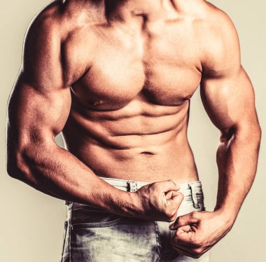 İyi eğitilmiş vücudu, pazıları, karın kasları ve kasları olan bağıran bir adam. Kaslı erkek kaslarını gerer ve çığlık atar. Beyaz arka planda poz veren kaslı vücut geliştirici