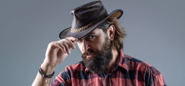 Kovboy şapkası. Kovboy şapkası takan genç bir adamın portresi. Şapkalı kovboylar. Yakışıklı sakallı maço. Tıraşsız kovboylar. Amerikan kovboyu. Deri