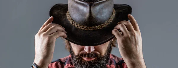 Cowboyok kalapban. Jóképű szakállas macsó. Borotvált cowboyok. Amerikai cowboy. Bőr Cowboy kalap. Egy cowboy kalapos fiatalember portréja. — Stock Fotó