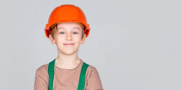 Kind verkleed als arbeider bouwer. Kleine jongen met een helm op. Portret kleine bouwer in hoeden. Kinderhelm, harde hoed. Kleine bouwer in helm — Stockfoto