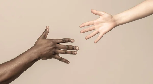 手、救助、多民族を助ける。手を助け、ジェスチャーを救出する。黒と白の人間の手。アフリカ人と白人の手。助けの手を差し伸べる。女性とアフリカの女性の手 — ストック写真