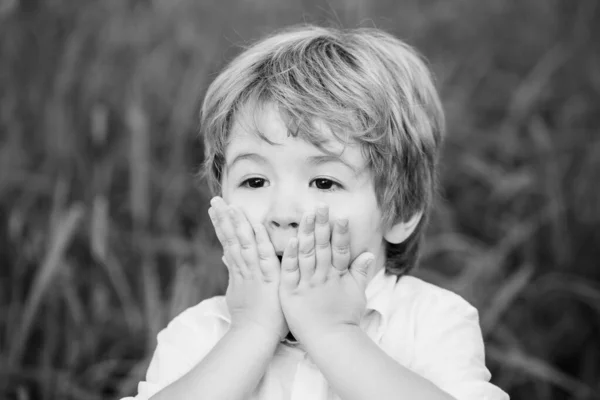 Niño divertido con las manos cerca de la cara aislado sobre fondo verde. Niño expresando sorpresa con las manos en la cara. Sonriendo niño sorprendido o sorprendido. Chico sorprendido y sorprendido — Foto de Stock