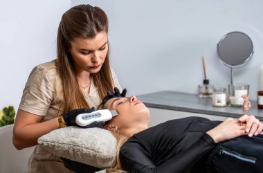 Güzellik doktoru ultrasonik temizleyici yüz temizleme prosedürü uyguluyor. Kozmetoloji, yüz bakımı. Cilt bakımı. Ultrasonik cilt temizleme prosedürü.