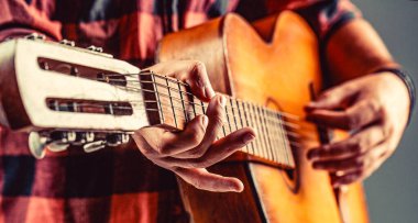 Gitar akustiği. Akustik gitarlar çalıyor. Gitar çalan erkek müzisyen, müzik aleti. Akustik gitar çalan erkek elleri, yakın çekim..