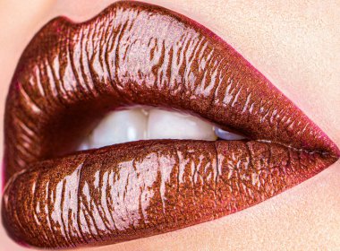 Çekici, kahverengi dudaklardan oluşan güzel bir ruj, güzel bir kadının yüzünde..