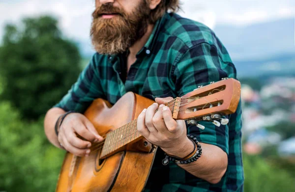 Akustik gitarlar çalıyor. Müzik konsepti. Gitar akustiği. Gitar çalan erkek müzisyen, müzik aleti. Gitar çalan müzik tarzı bir adam. Gitar çalan müzisyenin elleri.