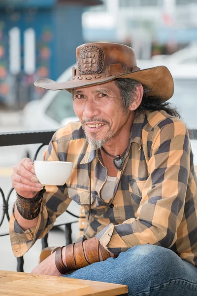 Aziatische cowboy met een kopje koffie — Stockfoto