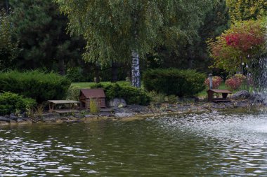 Small house for birds and ducks floating in the water in the park