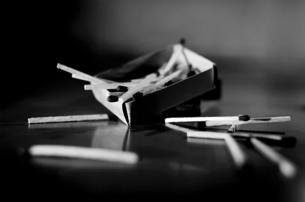 Match box and match sticks lying on floor monochrome