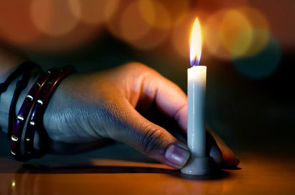 Mano sosteniendo vela en la noche oscura bokeh —  Fotos de Stock