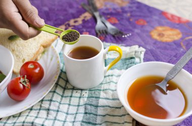 Siyah çay el çay çorba kaşığı içinde tutarak 