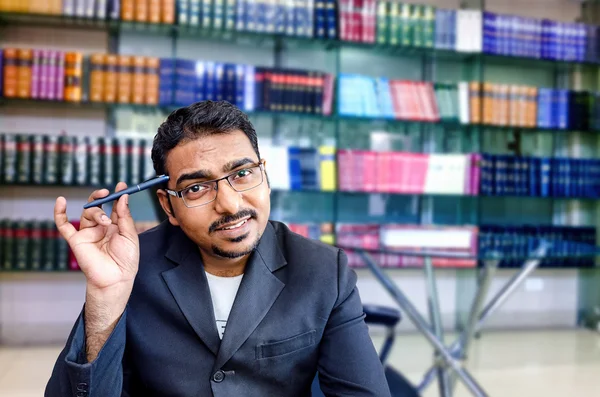 Porträtt av glad affärsman på office-biblioteket med penna — Stockfoto