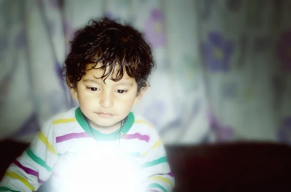 Boy child looking down on glow of light — Stock Photo, Image