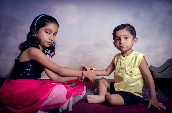 Irmã amarrando rakhi fio no pulso irmão tanto menina e menino loo — Fotografia de Stock