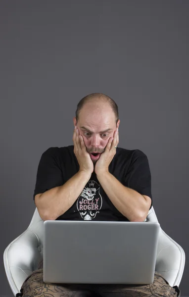 Bald young man has a problem with his laptop. — Stock Photo, Image