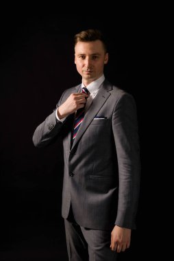 Genç beyefendi elbisesini düzeltiyor.