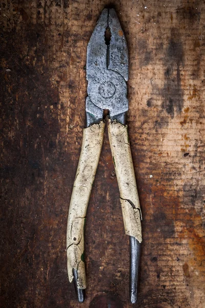 Pliers on wooden plank — Stock Photo, Image