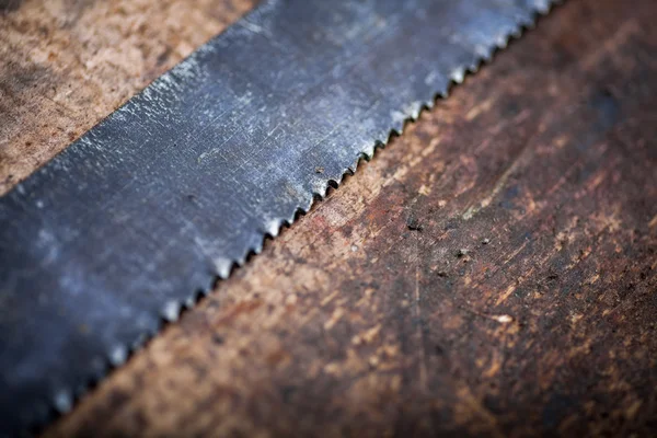 Hacksaw on wooden plank — Stock Photo, Image