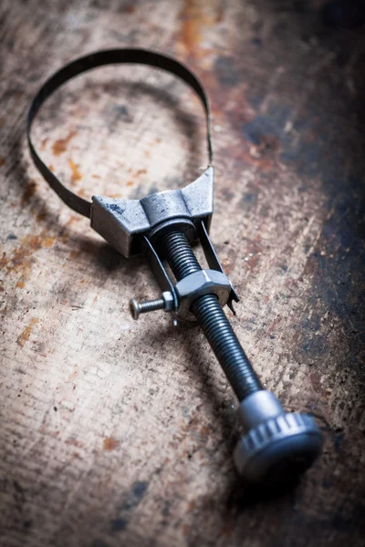 Oil filter removal tool on wooden plank — Stock Photo, Image