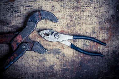 Ayarlanabilir anahtarı ve pense ahşap tahta üzerinde