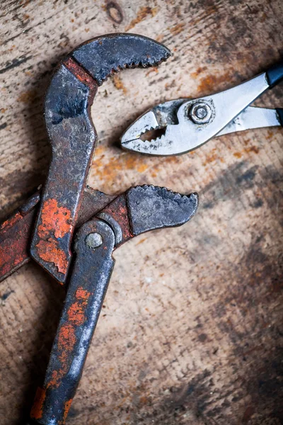 Ayarlanabilir anahtarı ve pense ahşap tahta üzerinde