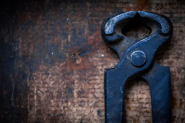 Pincers on wooden plank — Stock Photo, Image