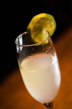 Bir dilim limonla kokteyl bardağını yakından çek..