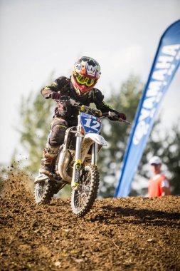 Ciolpani, Romanya - 11 Ekim 2002: Romanya 'nın Ciolpani kentinde düzenlenen bir motokros yarışına katılan bir çocuk sürücü motosikletiyle atladı.